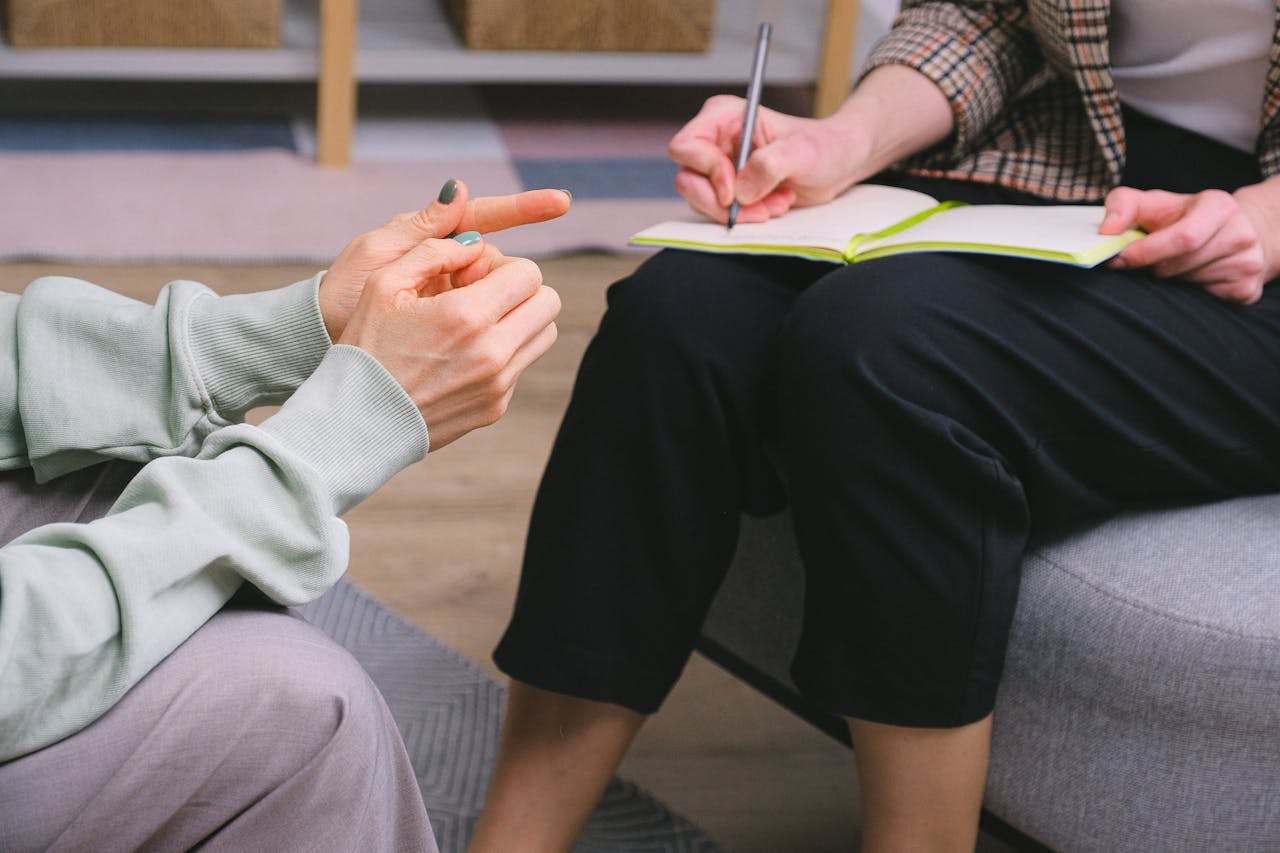 Close-up of a therapy session with a notebook and gestures indoors.